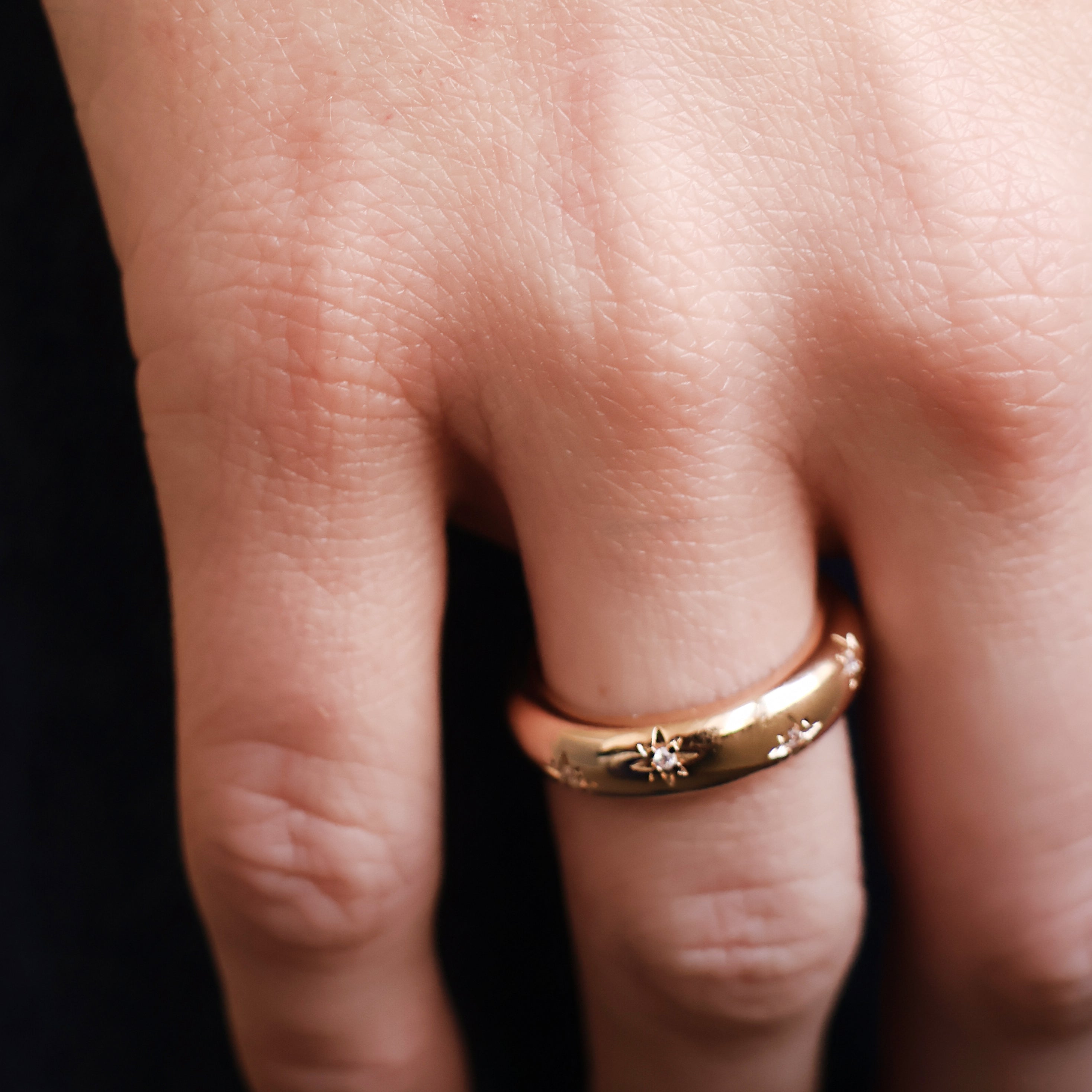 Bague Aria en plaqué or 18 carats – Un bijou raffiné orné de délicates étoiles gravées, chacune sublimée par un oxyde de zirconium scintillant. Son design élégant et moderne apporte une touche de magie et d’éclat à vos tenues. Féminine et sophistiquée, cette bague intemporelle est disponible en plusieurs tailles (50 à 60). Conçue en laiton avec un placage 5 microns et poinçon garantissant qualité et durabilité.