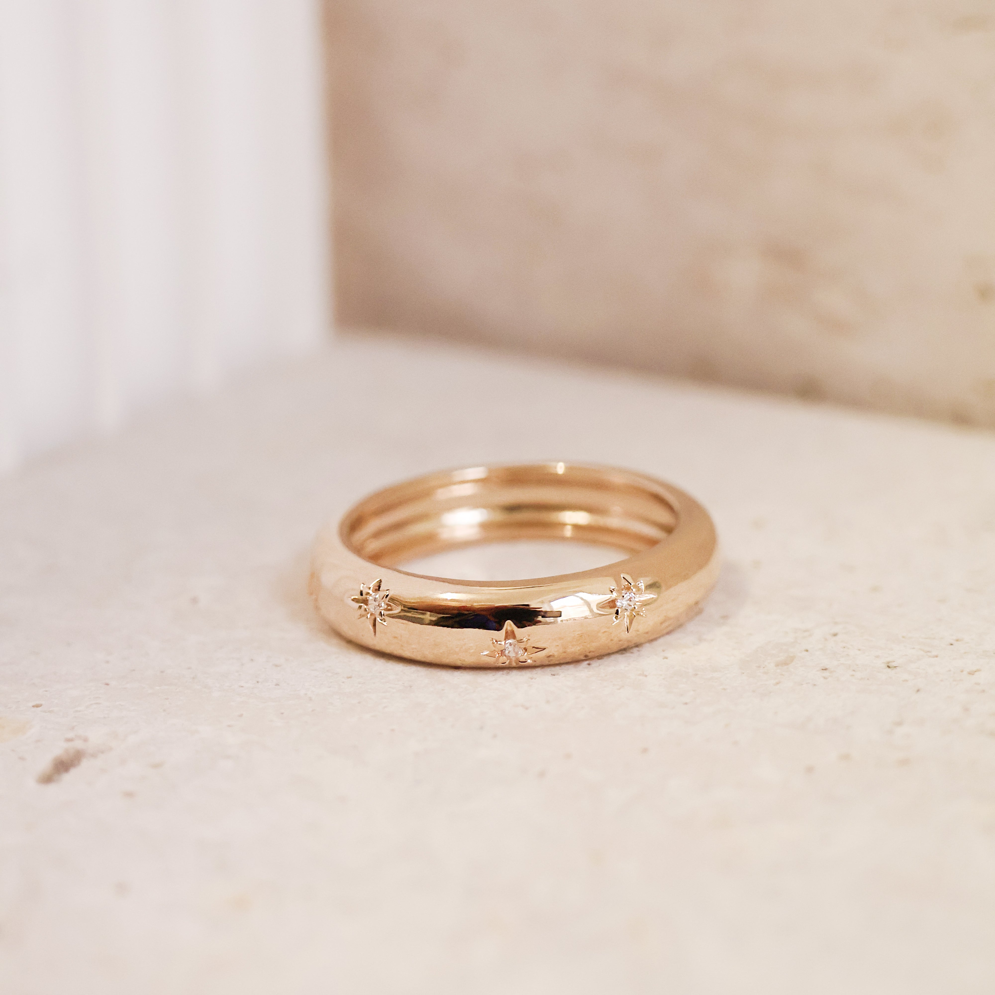 Bague Aria en plaqué or 18 carats – Un bijou raffiné orné de délicates étoiles gravées, chacune sublimée par un oxyde de zirconium scintillant. Son design élégant et moderne apporte une touche de magie et d’éclat à vos tenues. Féminine et sophistiquée, cette bague intemporelle est disponible en plusieurs tailles (50 à 60). Conçue en laiton avec un placage 5 microns et poinçon garantissant qualité et durabilité.