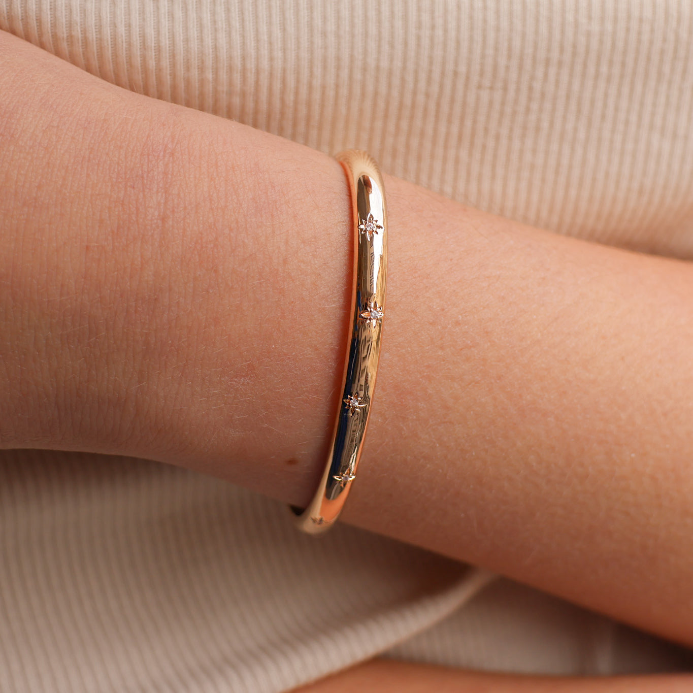 Bracelet jonc ouvert Aria en plaqué or 18 carats – Plongez dans un univers magique avec ce bijou raffiné, orné de deux étoiles serties d’oxydes de zirconium scintillants. Son design élégant sublime votre style et apporte une touche lumineuse à toutes vos tenues. Diamètre : 58 mm. Conçu en laiton avec un placage 3 microns et poinçon garantissant qualité et durabilité.