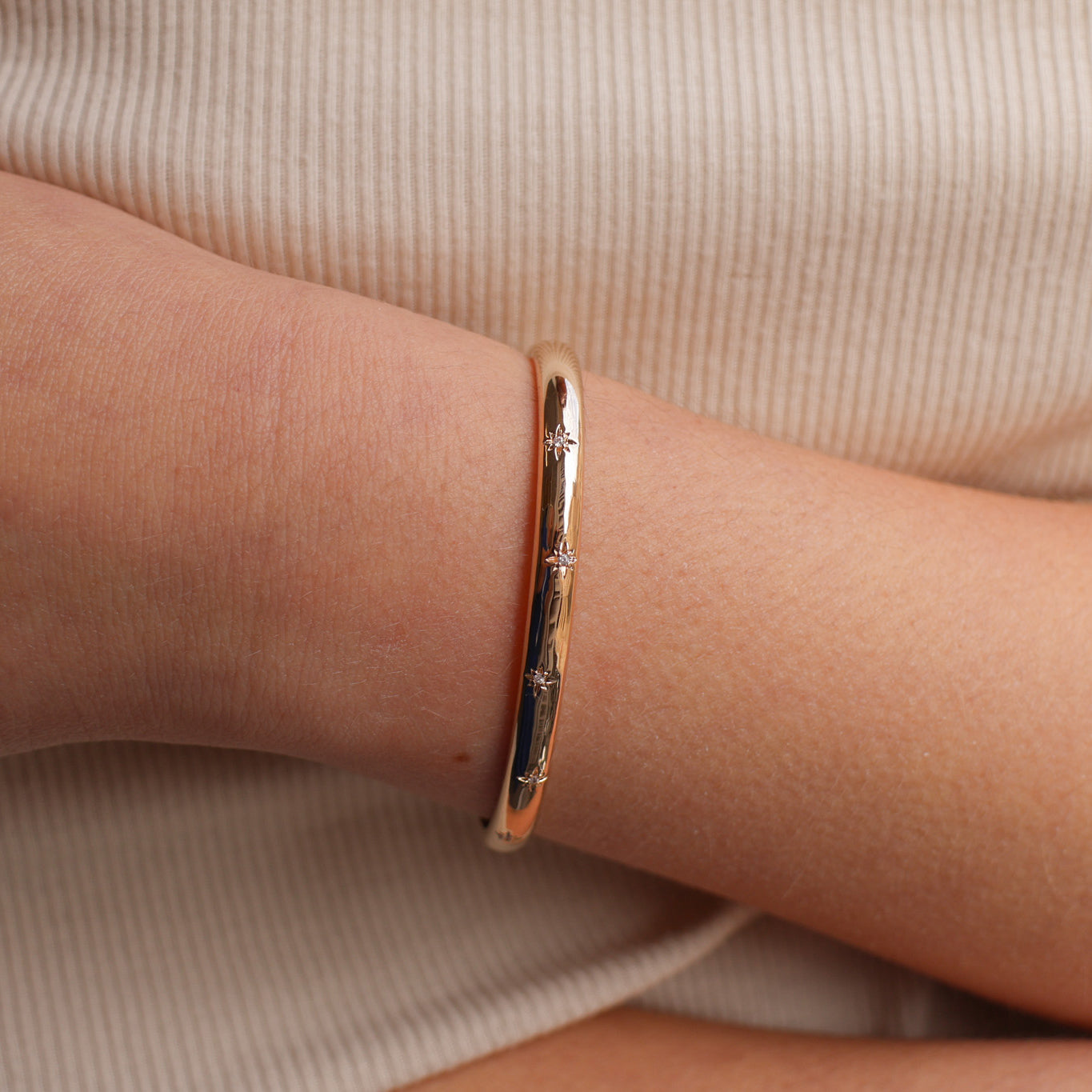 Bracelet jonc ouvert Aria en plaqué or 18 carats – Plongez dans un univers magique avec ce bijou raffiné, orné de deux étoiles serties d’oxydes de zirconium scintillants. Son design élégant sublime votre style et apporte une touche lumineuse à toutes vos tenues. Diamètre : 58 mm. Conçu en laiton avec un placage 3 microns et poinçon garantissant qualité et durabilité.