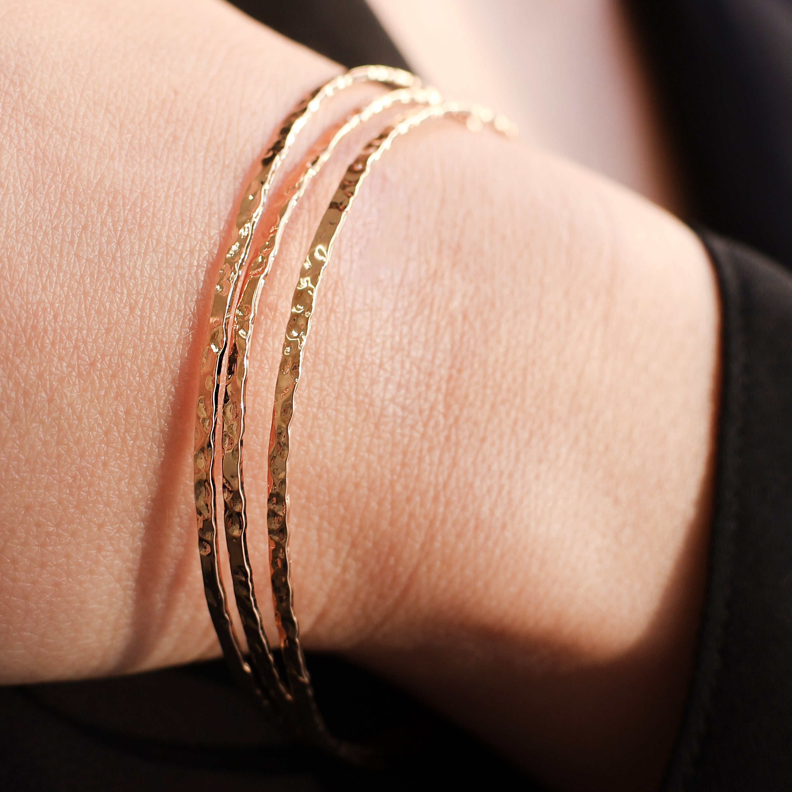 Bracelet Rosie en plaqué or 18 carats – Jonc élégant avec une finition martelée à l'extérieur et un intérieur lisse, offrant un jeu subtil de textures. Son éclat raffiné apporte une touche lumineuse à vos tenues et sublime votre style avec finesse. Diamètre 62 mm, conçu en laiton avec un placage 3 microns et poinçon garantissant qualité et durabilité.