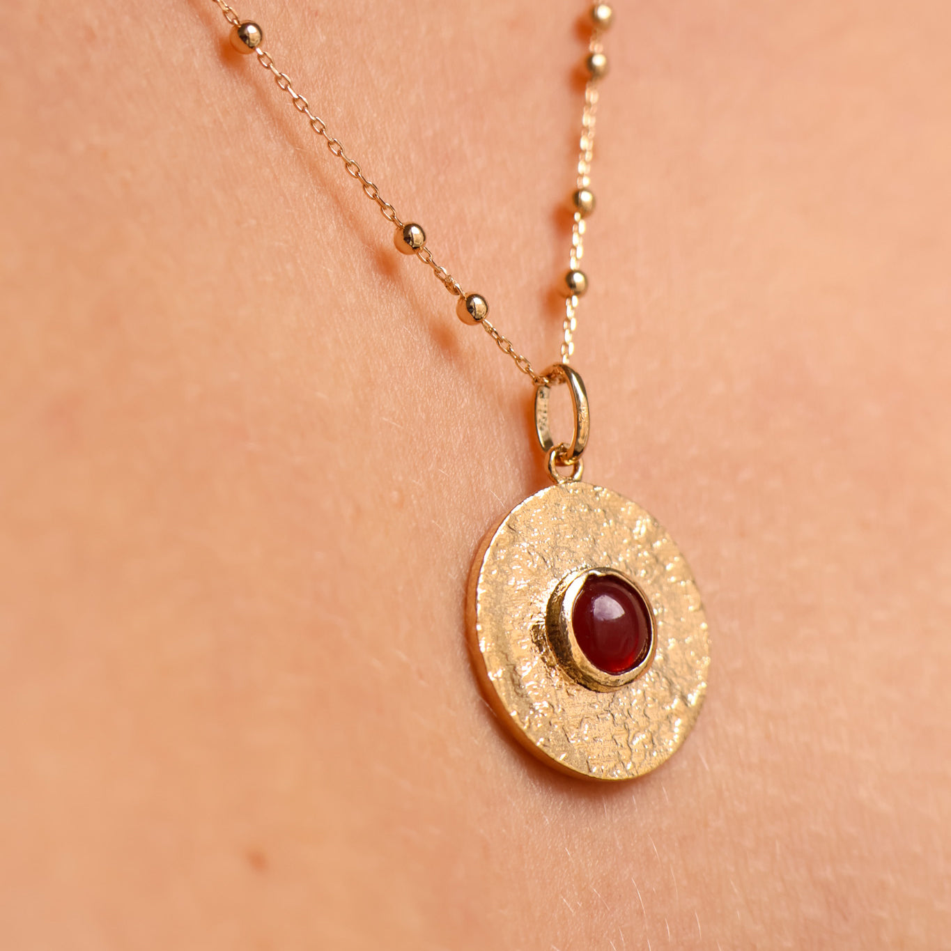 Round Layana pendant with satin finish, red stone and gold plated